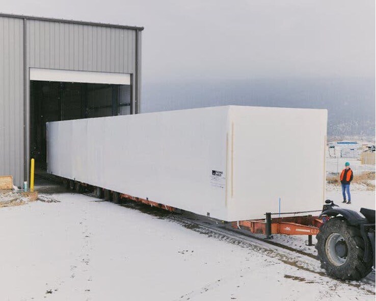 A completed Fading West module is towed from the facility to its site.